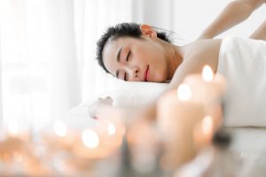 beautiful young woman beauty skin treatment relaxing lying towel massaging spa salon